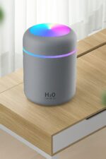 Humidificador H2O con Luz LED RGB funcionando con luces rgb sobre una mesa marrón claro