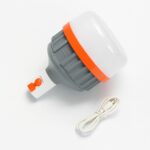 Luz LED recargable USB de 3000mAh con diseño portátil, cuerpo gris con borde naranja, acompañada de un cable de carga USB.