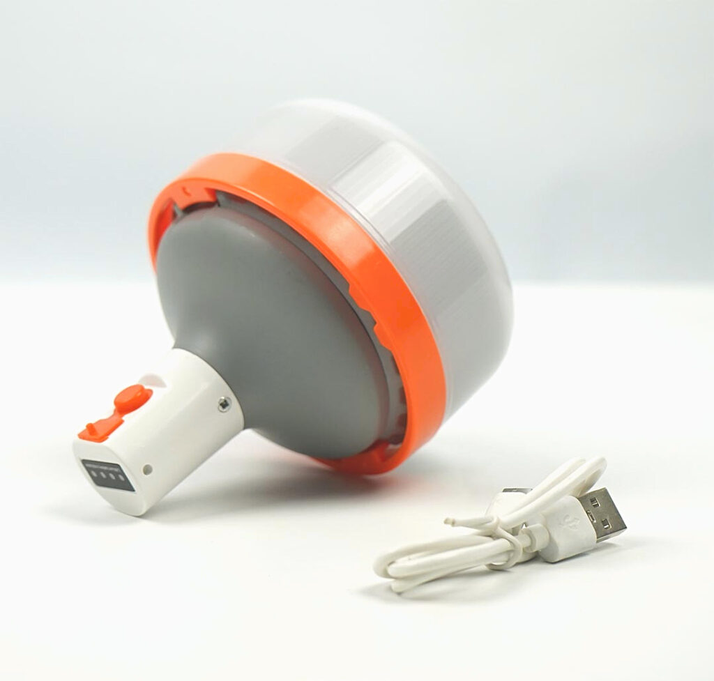 Luz LED recargable USB de 3000mAh con diseño portátil, cuerpo gris con borde naranja, acompañada de un cable de carga USB.