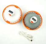 Luz LED recargable USB de 3000mAh vista desde arriba con diseño portátil, con borde naranja, acompañada de un cable de carga USB.